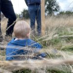 Kind sitzt im hohen Gras, Suche nach einem Grundstück